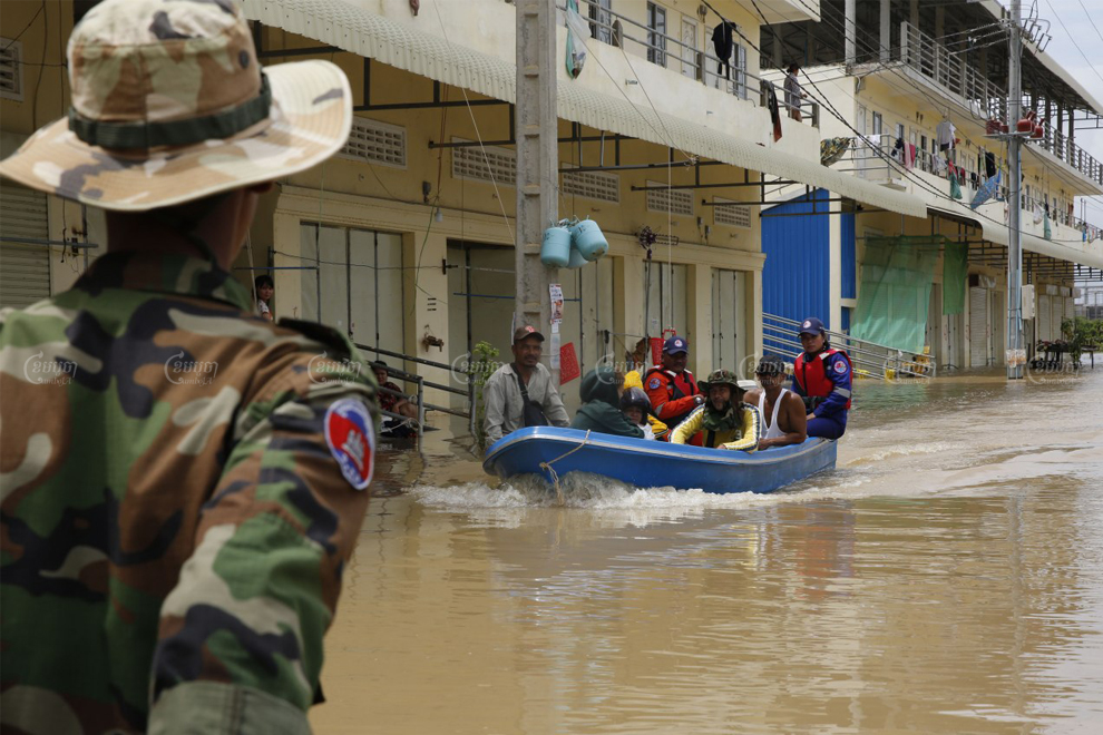 Dangkor district residents head home on a motorboat accompanied by rescue officials on October 20. Panha Chhorpoan