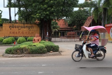 A motorist rides past the closed gates of the Cambodian Cultural Village in Siem Reap on November 11. Panha Chhorpoan