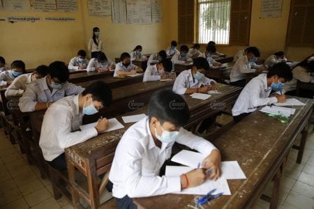 Students take the Grade 9 national examination at Sisowath high school on Monday, as a new COVID-19 cluster resulted in the Education Ministry cancelling the rest of the school year. Panha Chhorpoan