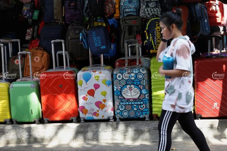 A woman walk pass suitcase shop in Phnom Penh on January 9, 2021. Travel goods exports will be tariffed till the U.S reauthorizes the GSP program. Panha Chhorpoan