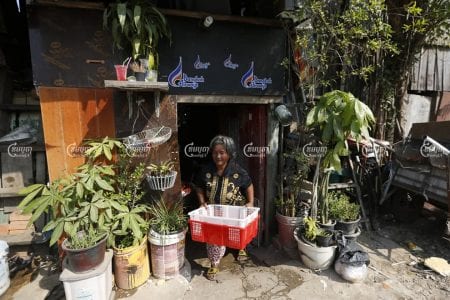 Iev Mach walks out of her home, which is set to be demolished to make way for a new road, in Toul Kok district on January 15. Panha Chhorpoan