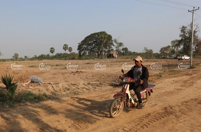 A villager rides past the disputed land in Kandal province’s Ksach Kandal district on February 16. CamboJA/Pring Samrang