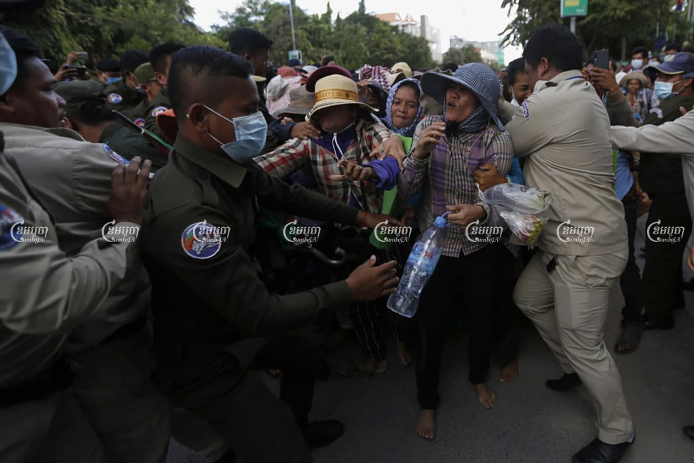 Police and security guards force land protesters to the edge of Monivong Boulevard after they blocked the street outside the Land Management Ministry on September 21. Panha Chhorpoan