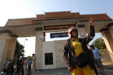 Sao Na stands in front of the Kandal Provincial Hall on Friday before receiving compensation along with 1,000 others in a long-running dispute with her former employer. CamboJA/Pring Samrang