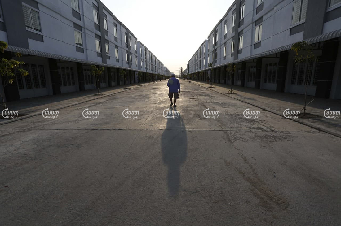 A man walks past houses in a Phnom Penh borey on March 23. CamboJA/Panha Chhorpoan