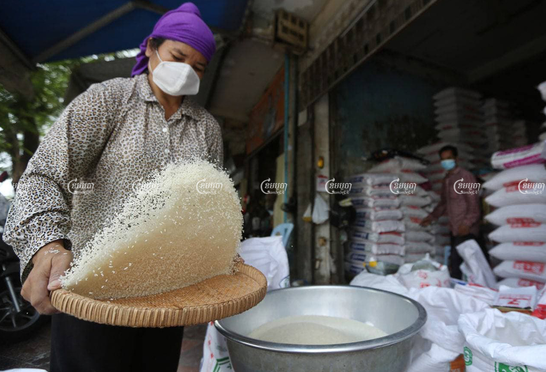 A woman sifts through rice at a store in Phnom Penh on March 25.CamboJA/Pring Samrang
