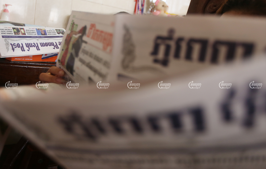 A woman reads the print edition of the Phnom Penh Post newspaper, which stopped the presses during Phnom Penh lockdown, April 20, 2021. CamboJA/ Pring Samrang