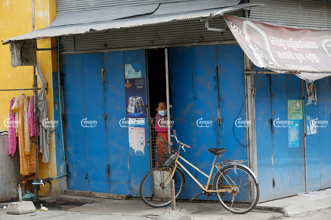 A woman stares out of the door of her rental room in the red zone at Stung Meanchey III commune in Phnom Penh, April 23, 2021. CamboJA/ Panha Chhorpoan