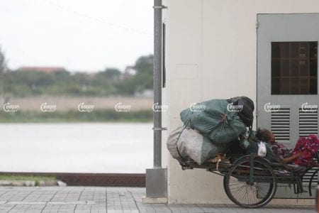 A woman with disabilities rests on her scrap cart near the Tonle Sap river in Phnom Penh, August 16, 2016. CamboJA/ Pring Samrang