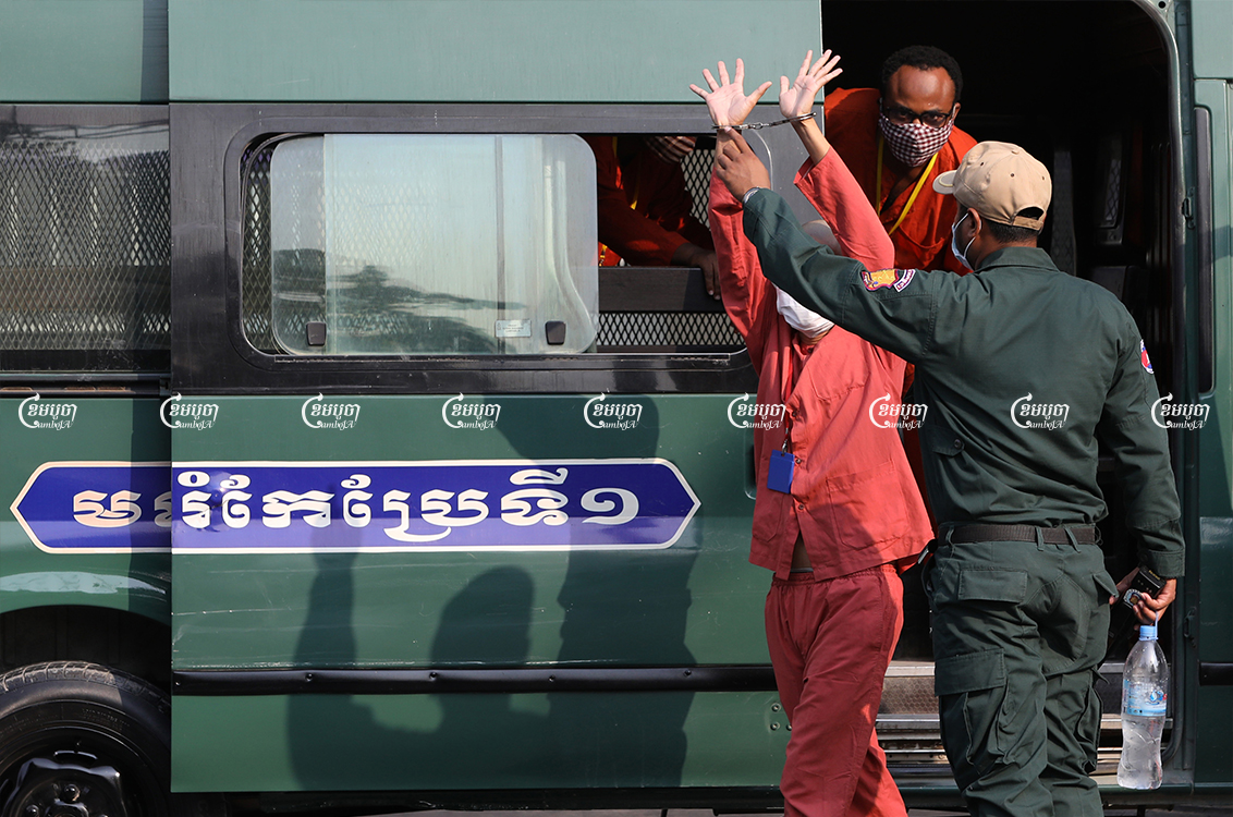 Inmates leave a crowded prison van on their way to a hearing at Phnom Penh Municipal Court, March 31, 2021. CamboJA/ Pring Samrang