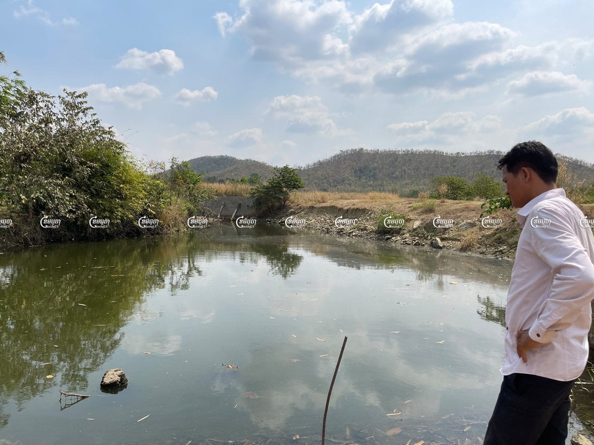 A villager in Kampong Speu looks at the O'Brong stream, which has become polluted and undrinkable after the opening of a factory nearby, January 2021. CamboJA/ Sorn Sarath