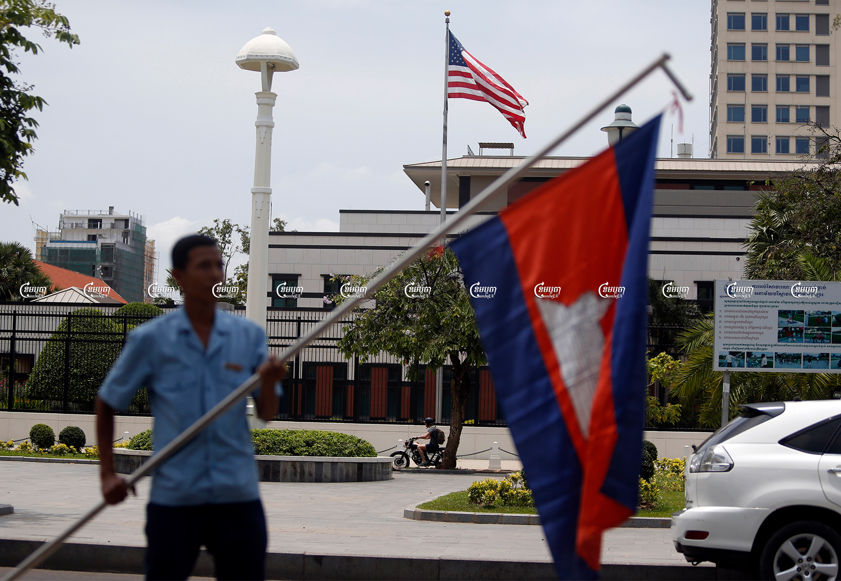 A man holds a Cambodian flag in front of the U.S. Embassy in Phnom Penh, Picture taken on April 13, 2018. CamboJA/ Pring Samrang