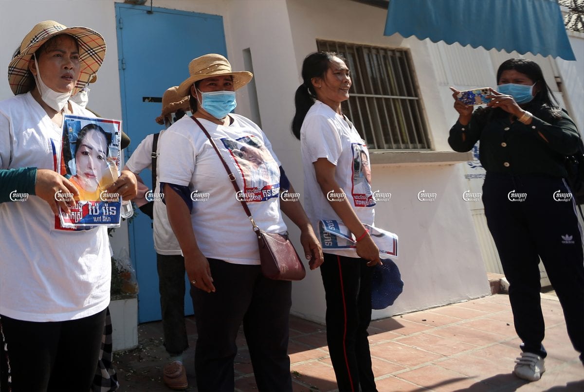 A woman broadcasts a Facebook live video of a protest outside the UN office in Cambodia carried out by family members of former opposition activists. Picture taken on June 4, 2021. CamboJA/ Pring Samrang