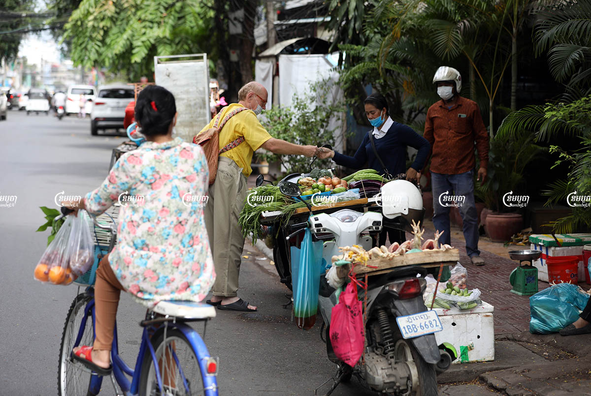 Vendors sell food along a street in Phnom Penh after their market closed due to Covid-19 restrictions, July 23, 2021. CamboJA/ Pring Samrang
