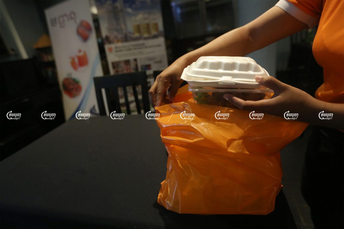 A staff member packs food for a customer at a restaurant in Phnom Penh, August 10, 2021. CamboJA/ Pring Samrang