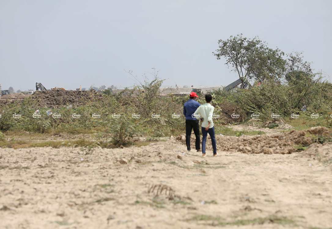 Villagers walk across their plot of land in Kandal province. The plot is part of a large swathe of land that will become the site of a new airport. Picture taken March 2, 2021. CamboJA/ Pring Samrang
