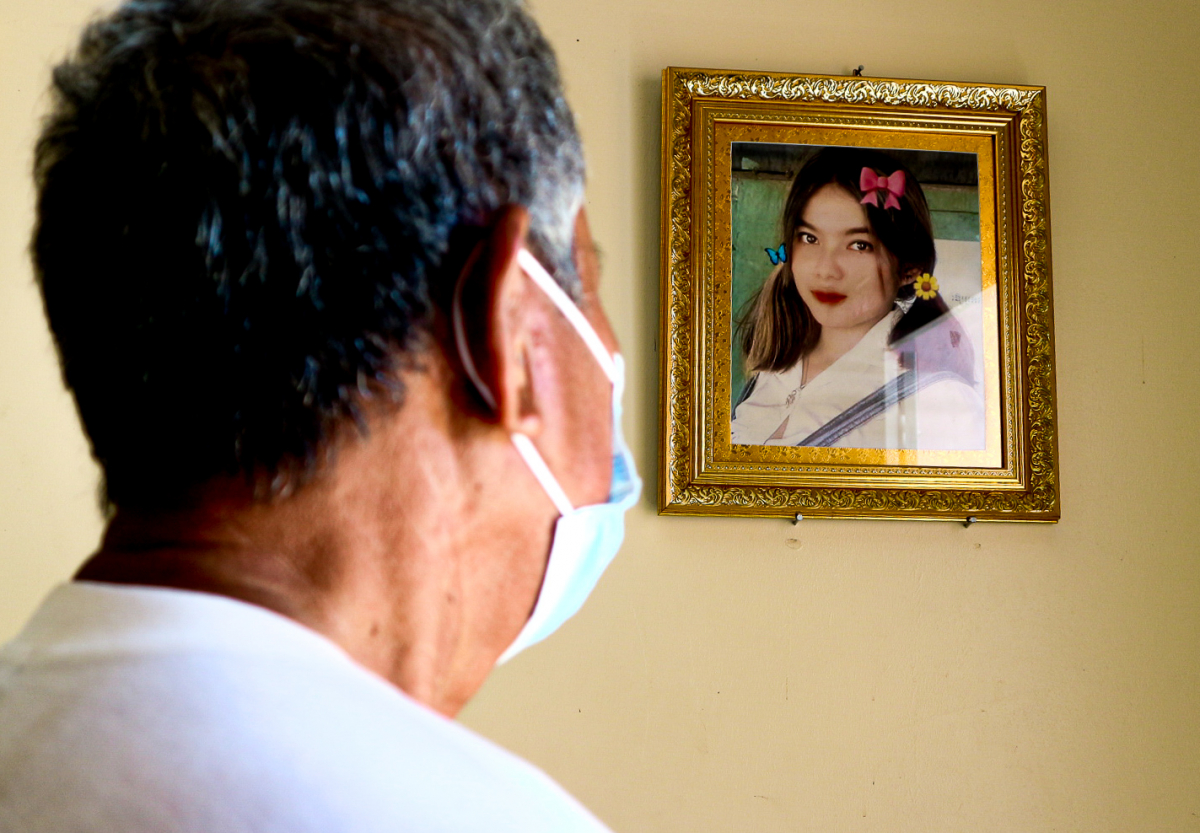 Ly Koeung, father to the 20-year-old girl who died in a road accident, looks at his daughter’s photo hanging on the wall in his home, in Kampong Chhnang province, October 24, 2021. (Kann Vicheika/VOA Khmer)
