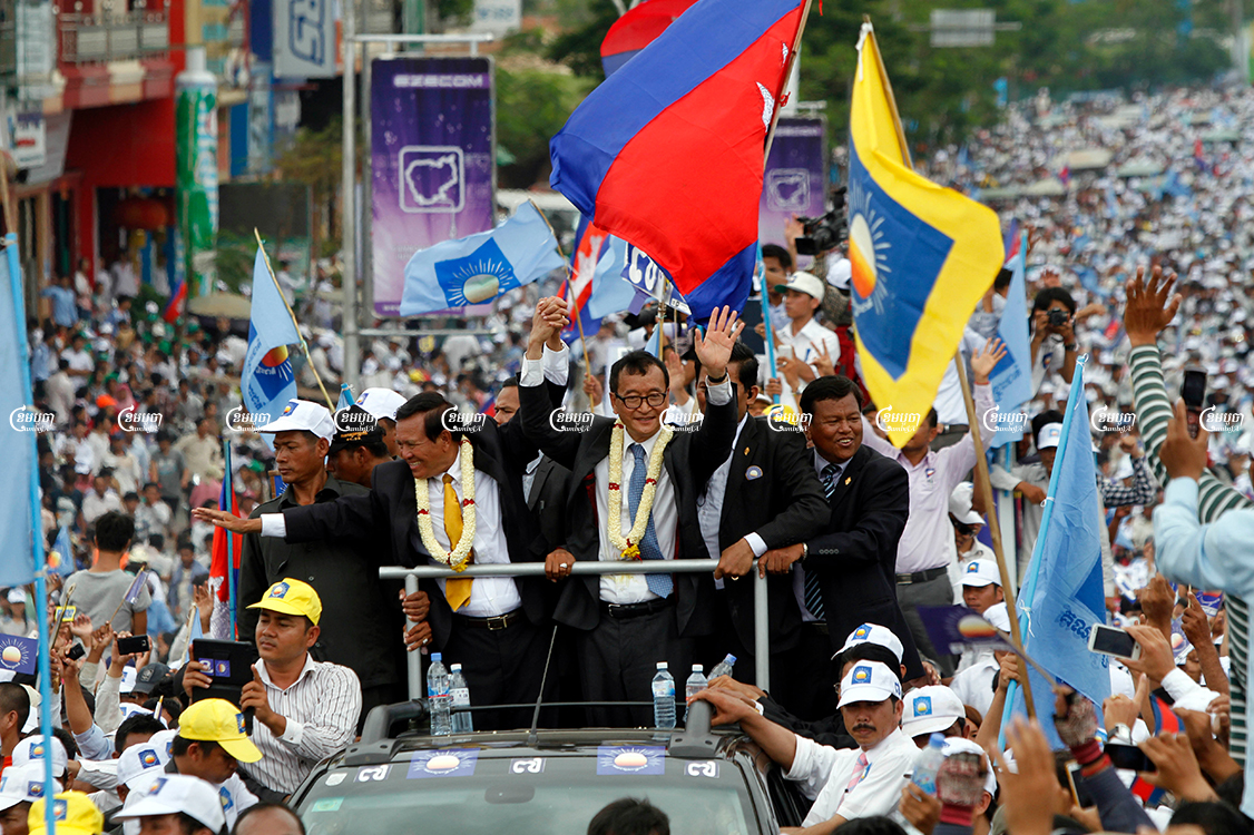 Former CNRP president Sam Rainsy (Center Right) and vice president Kem Sokha greet supporters during Rainsy's 2013 homecoming to Phnom Penh. Picture taken July 19, 2013. CamboJA/ Pring Samrang