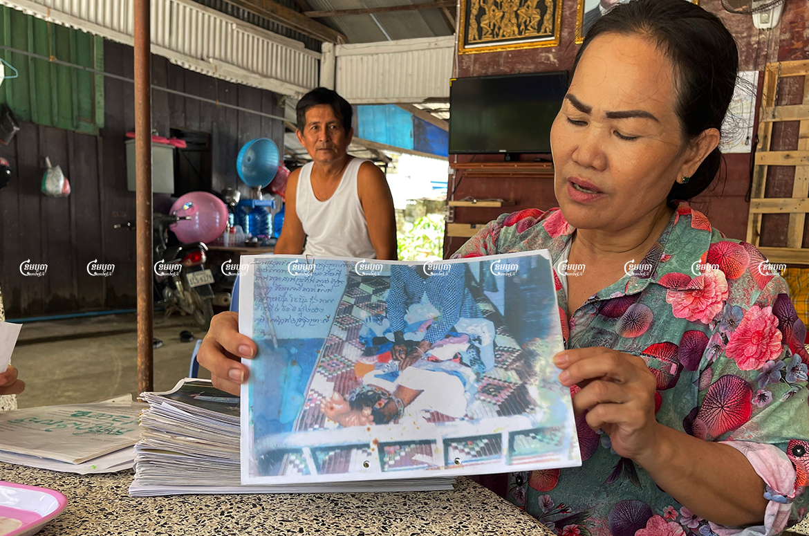 Hang Chinda, 55 years old and a representative of the 24 remaining families in the dispute, shows a picture of her mother, who was handcuffed to a bed while imprisoned in 2002 after an arrest related to the land conflict. Photo taken October 26, 2021. CamboJA/ Sorn Sarath