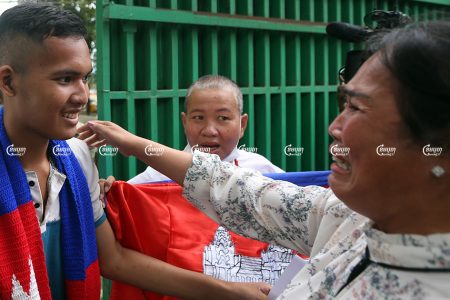 Kak Sovann Chhay smiles as his mother Prum Chantha cries and hugs him after his release from jail in Phnom Penh, November 10, 2021. CamboJA/ Pring Samrang
