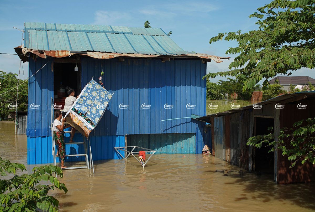 People carry their belongings out of their flooded home in Dangkor district’s Kongnoy commune in Phnom Penh, Picture taken October 26, 2021. CamboJA/ Panha Chhorpoan