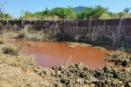 An orange pond, which villagers suspected of having high toxin levels, can be seen near the mining operations of Delcom in Rovieng district, Preah Vihear province. Photo taken on December 14, 2021. CamboJA / Vann Vichar