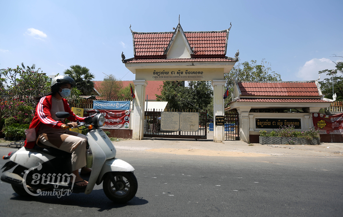 A woman drives past a school closed during the COVID-19 outbreak in Phnom Penh. Picture taken March 11, 2021. CamboJA/ Pring Samrang