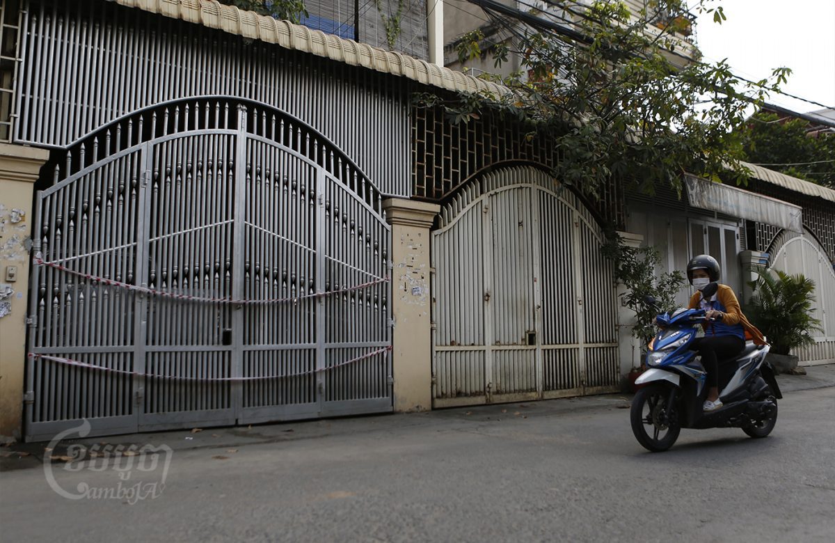 A woman drives past a house from which a family member tested positive for Omicron variant in the Meanchey district of Phnom Penh. CamboJA / Panha Chhorpoan