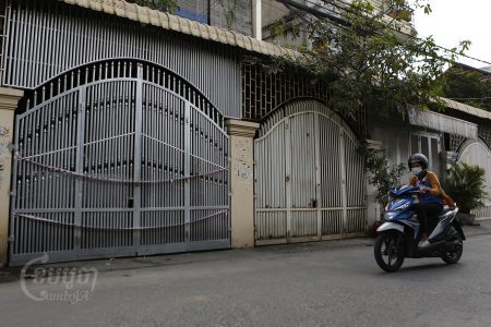 A woman drives past a house from which a family member tested positive for Omicron variant in the Meanchey district of Phnom Penh. CamboJA / Panha Chhorpoan