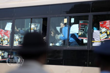 NagaWorld employees shout for help as authorities force them into a city bus. Police and other officials detained the employees as they had been returning to their strike near the NagaWorld casino complex in Phnom Penh, February 21, 2022. CamboJA/ Pring Samrang