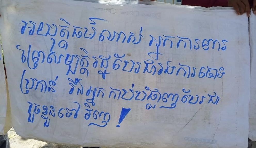 Villagers protesting in front of Kampong Speu court, February 23, 2022. The banner calls out the injustice of legal action being brought against forest activists instead of those who destroy it. CCFC