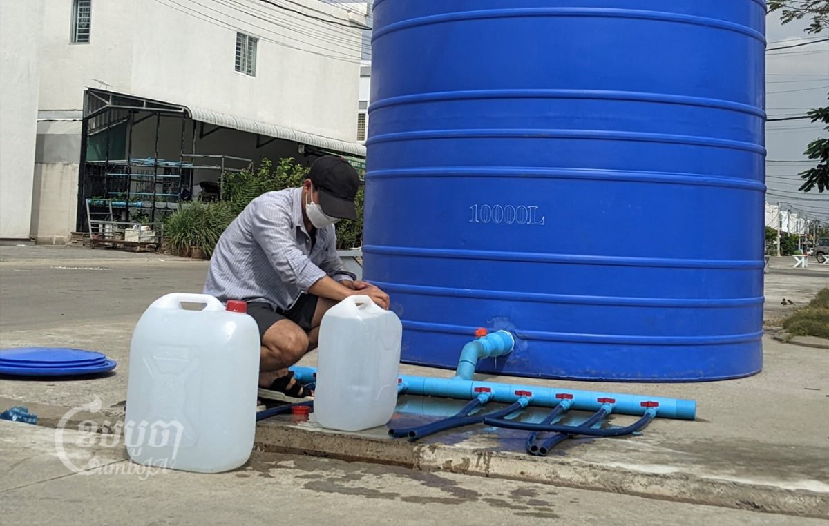 A man takes water from a basin for daily use in Borey Piphup Thmey Chhouk Va II where people are facing a severe water shortage. Picture taken on February 1, 2022. CamboJa/ Sovann Sreypich