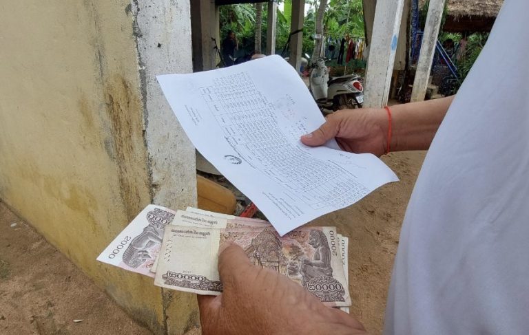 A man receives money from the CPP working group his commune after he joined a meeting in Kandal province. Picture taken April 30, 2022. CamboJA/ Kheang Sokmean