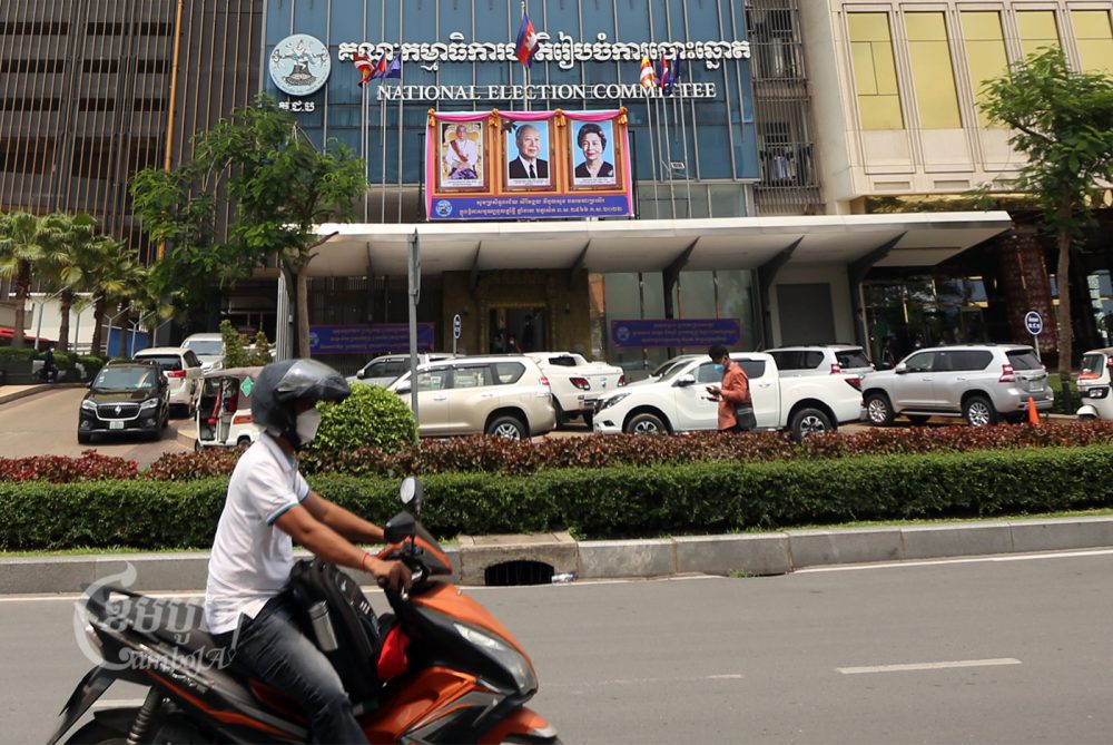 A motorist drives past the National Election Committee office in Phnom Penh on April 11, 2022. (CamboJA / Pring Samrang)