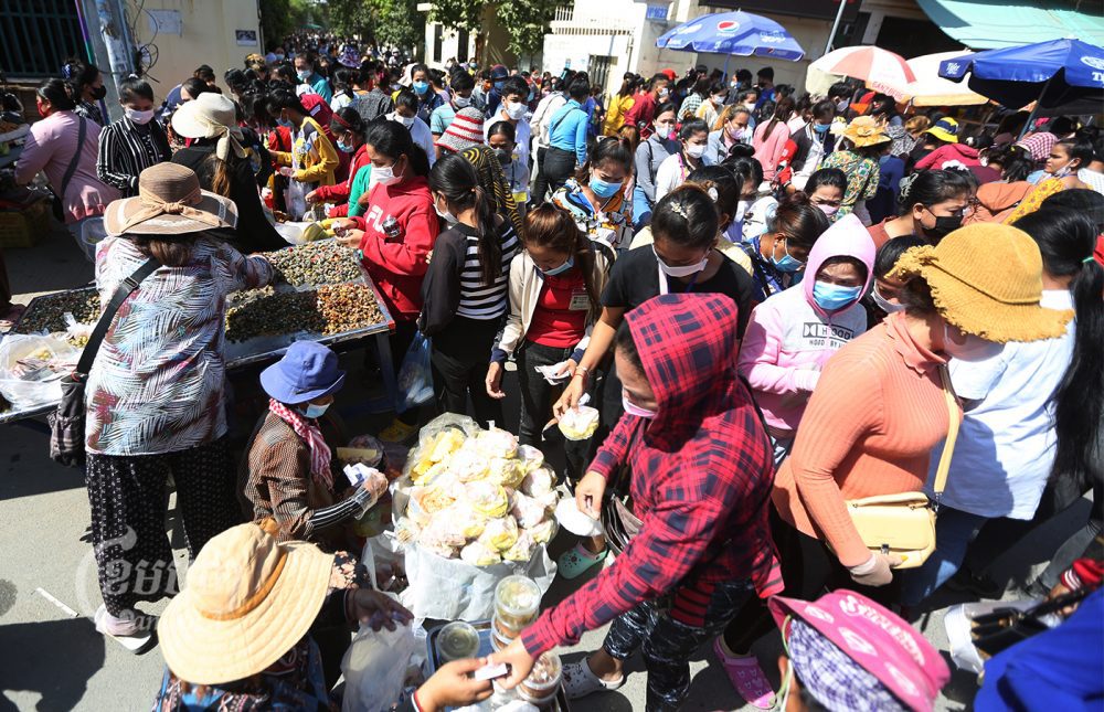 Garment workers buy food for their lunch in front of a factory on the outskirts of Phnom Penh, Picture taken January 14, 2022. CamboJA/ Pring Samrang