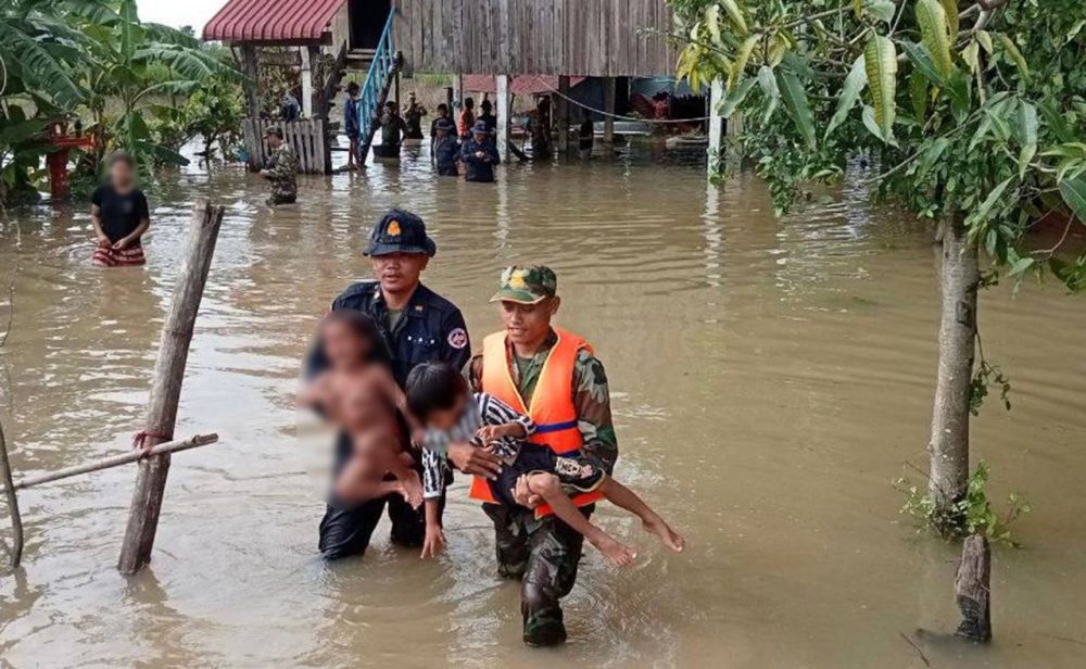 Authorities carry children from a house surrounded by floodwaters in Banteay Meanchey province’s Malai district on September 30, 2022. Supplied