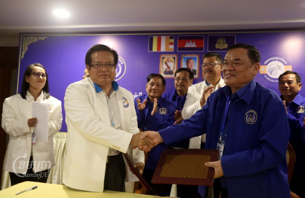 Yem Ponhearith (left), president of the Kampuchea Niyum Party, shakes hands with Nhek Bun Chhay (right), president of the Khmer National United Party, during a meeting to announce their new alliance at Sunway Hotel in Phnom Penh on October 10, 2022. (CamboJA/Pring Samrang)