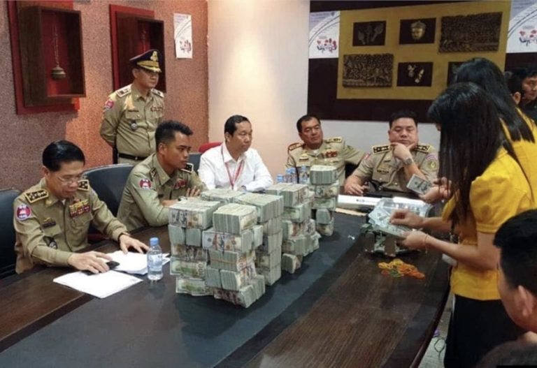 Cambodian police pose for a photo with $3.5 million in cash confiscated from Chinese nationals, posted on the National Police Facebook page in 2019.