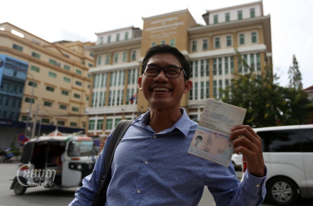 Yeang Sothearin, a former Radio Free Asia journalist, smiles as he holds up his passport, which was returned to him by the Phnom Penh Municipal Court on October 28, 2022. CamboJA/Pring Samrang