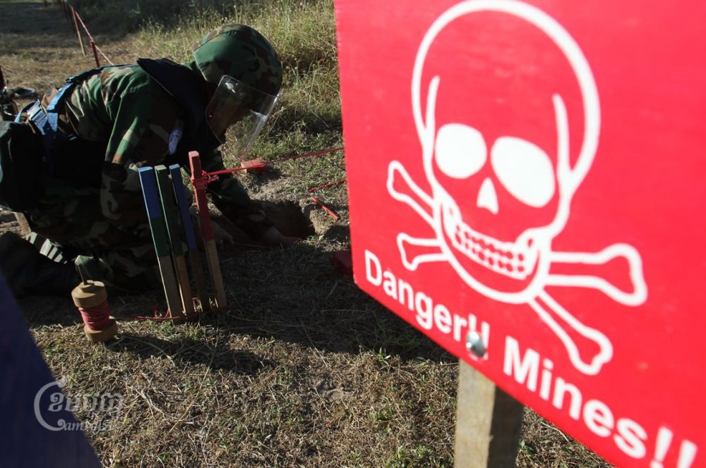 A Cambodian deminer holds a metal detector at a testing area in a minefield during a demonstration for the media at a demining center in Kampong Speu province, on November 27, 2011. CamboJA/Pring Samrang