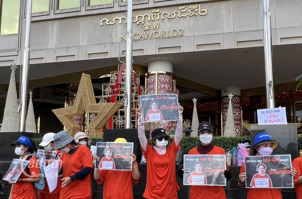 NagaWorld strikers wore symbolic orange prison jumpsuits in front of NagaWorld’s casino as they called for the release of detained union leader Chhim Sithar on December 5, 2022. (CamboJA/ Sovann Sreypich)