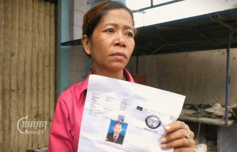 Keo Vandy holds a copy of her missing husband’s identification as she waits to hear news near Trach pagoda in Poipet on December 30, 2022. (CamboJA / Jack Brook)