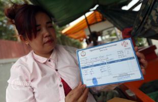 Thoeun Sophea shows her Pac Card as she sells some drinks in front of a factory on the outskirts of Phnom Penh, January 05, 2023. CamboJA/ Pring Samrang