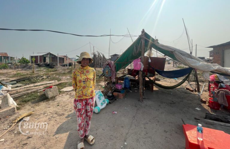Hoeum Chhat, who said she had “no choice” to relocate to Run Ta Ek, stands outside her new home at the site on March 8, 2023. (CamboJA Staff)