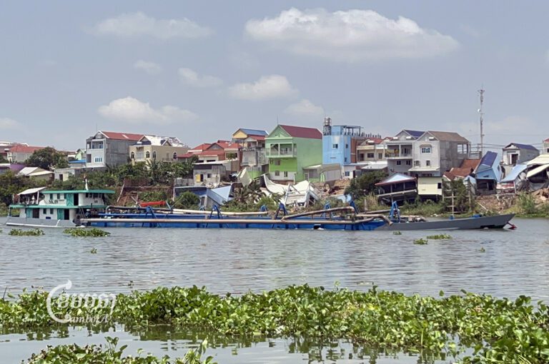 A ferry carrying sand takes past houses collapse at Bassac’s river bank in Prek Koy commune, Sa’ang district, Kandal province, April 25, 2023. (CamboJA/Sovann Sreypich)