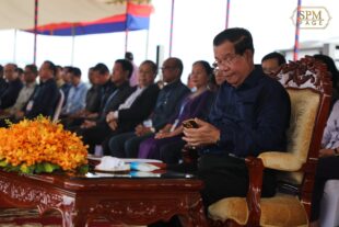 Prime Minister Hun Sen looks at his phone during a meeting with garment workers in Phnom Penh, June 13, 2023. (Hun Sen’s Facebook)