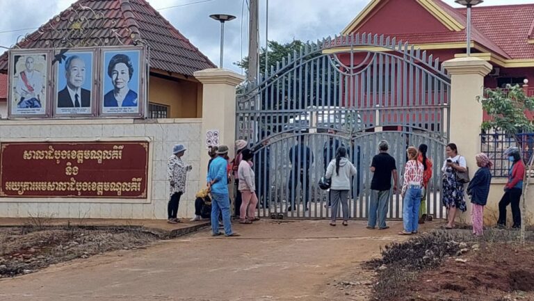 Police officials guarding Mondulkiri Provincial Court close the court's gate while relatives of three arrested Bunong people stand outside, on June 6, 2023. (Photo: Supplied)