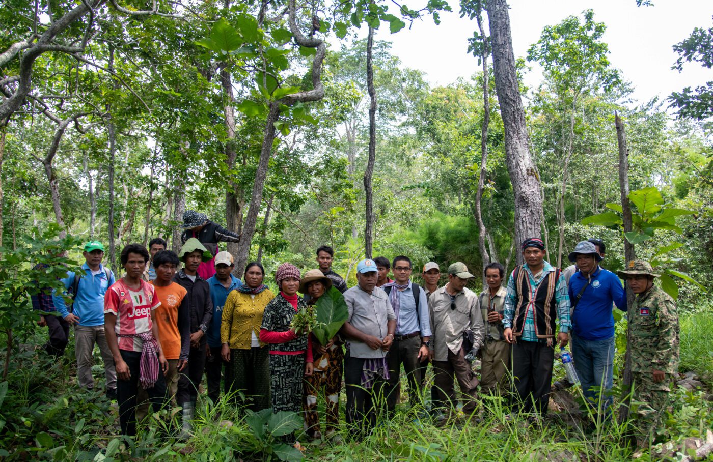 Members of Roya commune’s 100 Bunong families, World Bank officer Peth Kim Nguy and district authority representatives pose for a group photo near a Bunong burial ground in the middle of the World Bank’s Social Land Concession. (CamboJA/Andrew Califf)