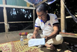Ma Sarim holds a document for a loan he used to invest in the Piphup Deimeas company, photographed on August 23, 2023. (CamboJA/Sovann Sreyich)