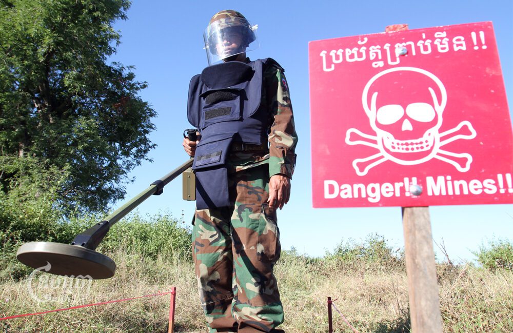 A Cambodian deminer uses a metal detector at a testing area in a minefield during a demonstration for the media at a demining center in Kampong Speu province, on November 27, 2011. (CamboJA/Pring Samrang)